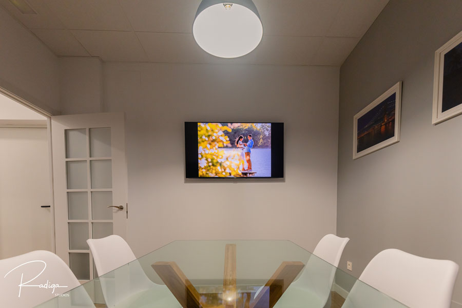 Pared del estudio con una fotografía enmarcada y la pantalla para ver reportajes