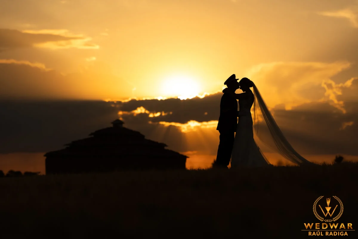 Silueta de pareja de novios al atardecer junto a un palomar. Boda en el Ermitaño de Benavente