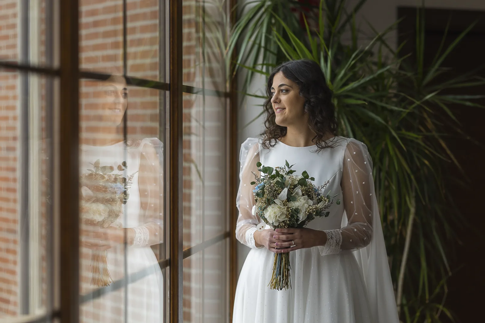 La novia con el ramo junto a la ventana antes de salir