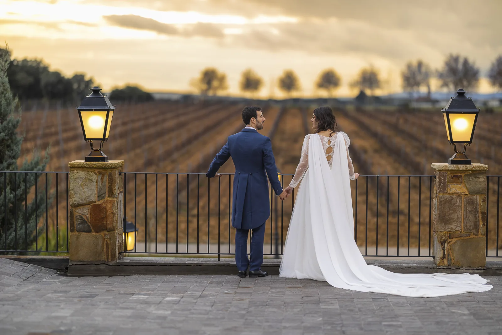 Los novios en la terraza al atardecer, frente a los viñedos