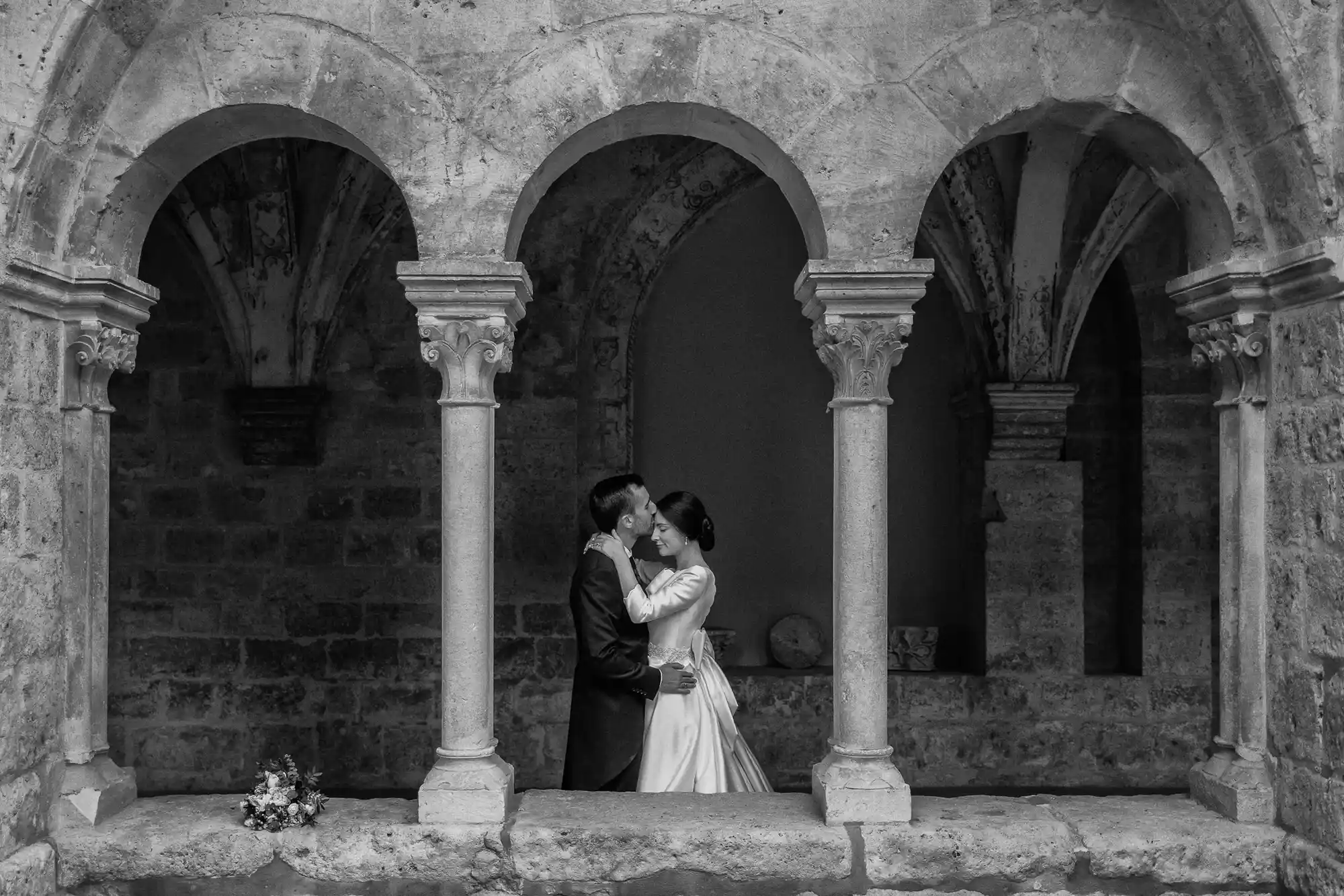 Novios bajo los arcos de piedra del claustro del Monasterio de Valbuena