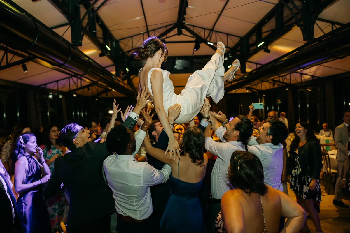Los amigos mantean a la novia en la pista de baile al final de la noche