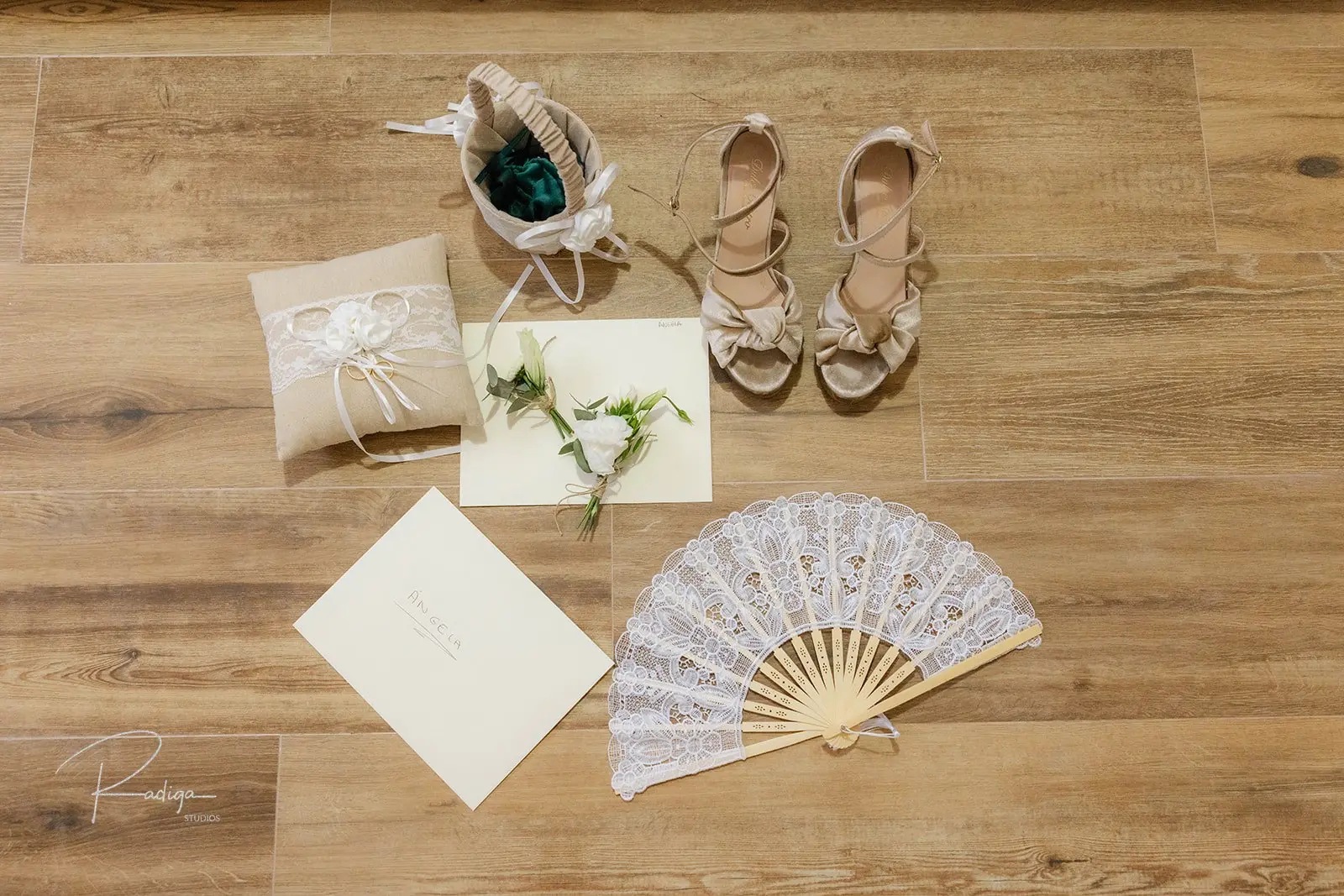 Zapatos, abanico, anillos y detalles de la novia sobre una mesa de madera
