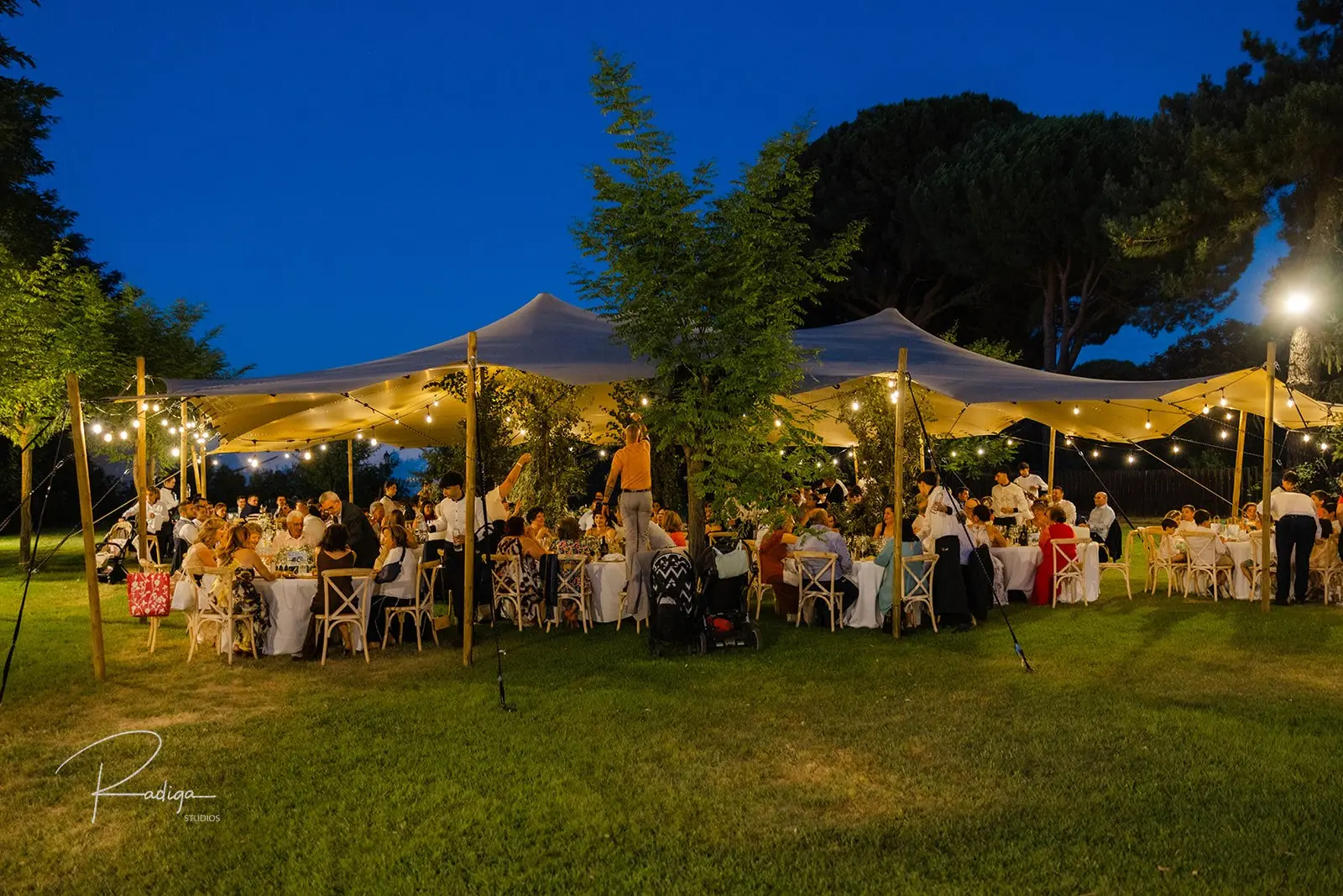 El banquete bajo las carpas iluminadas del jardín de Dehesa de los Canónigos al anochecer