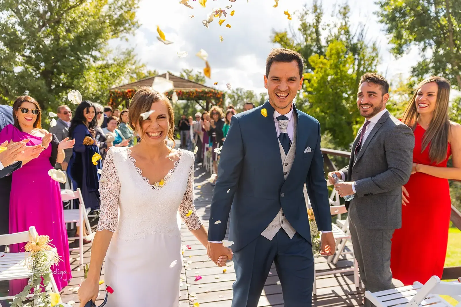 Los novios salen de la ceremonia de la mano entre los invitados