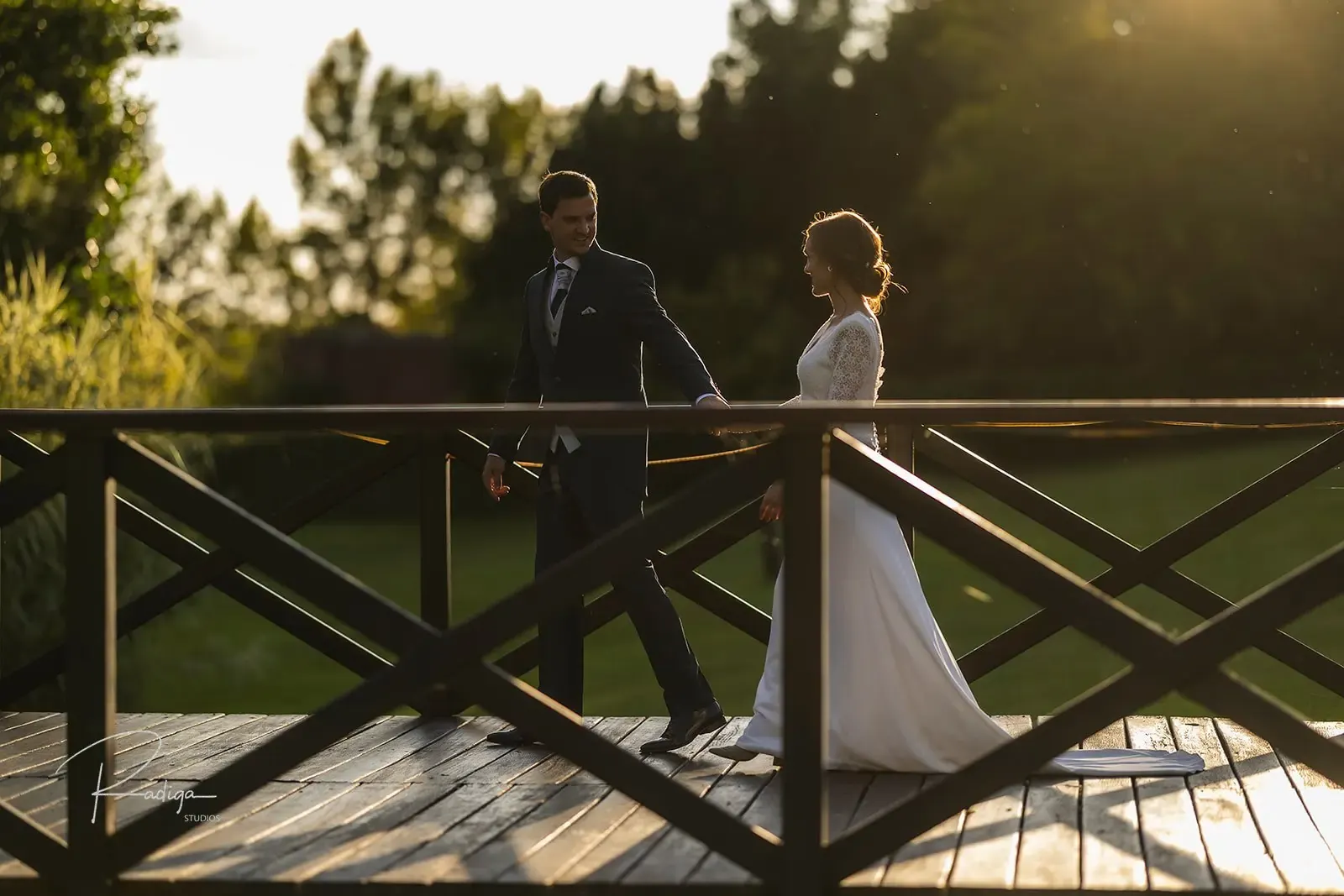 Los novios en el puente de madera con la luz dorada de la tarde