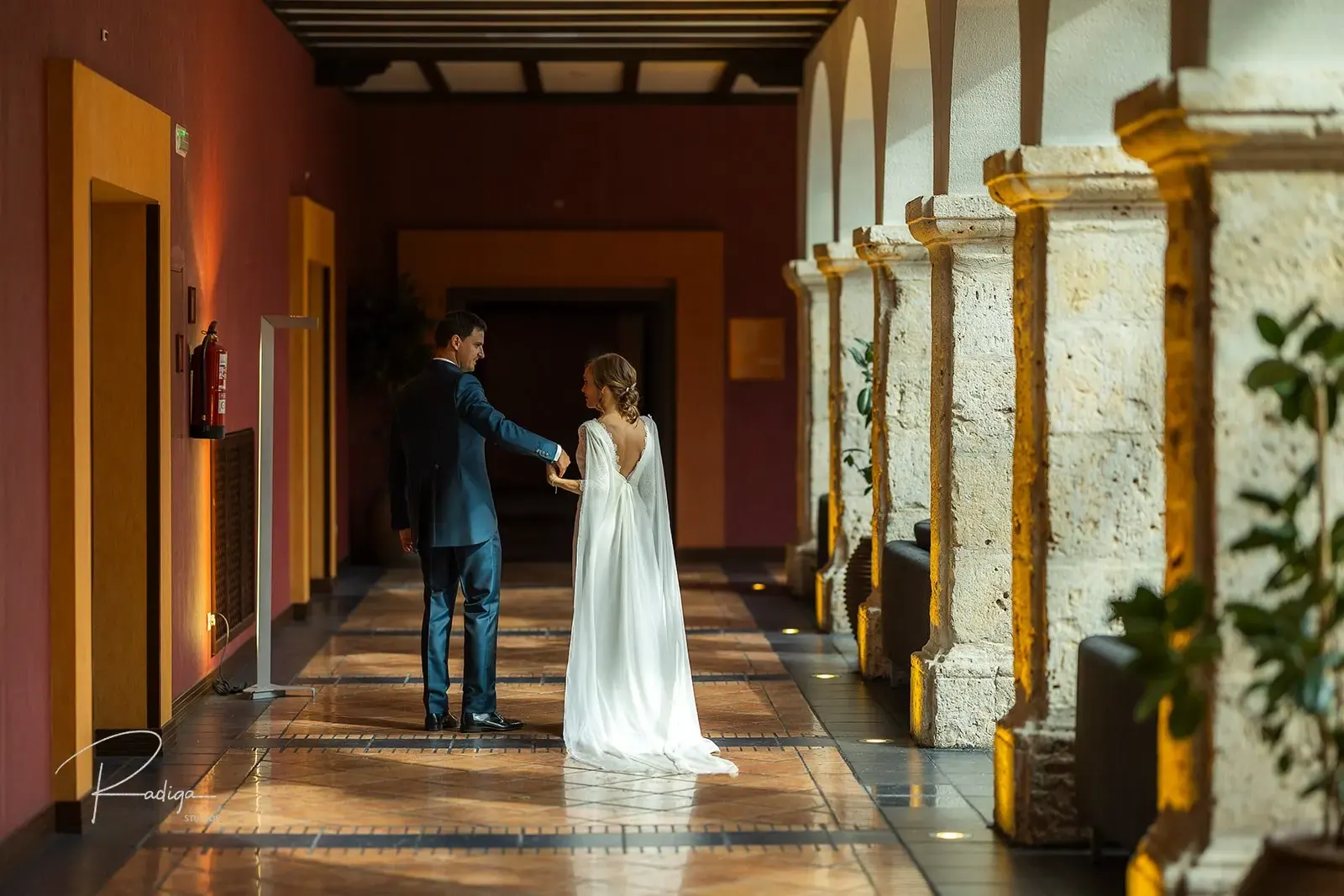 Los novios caminan por la galería de columnas del claustro