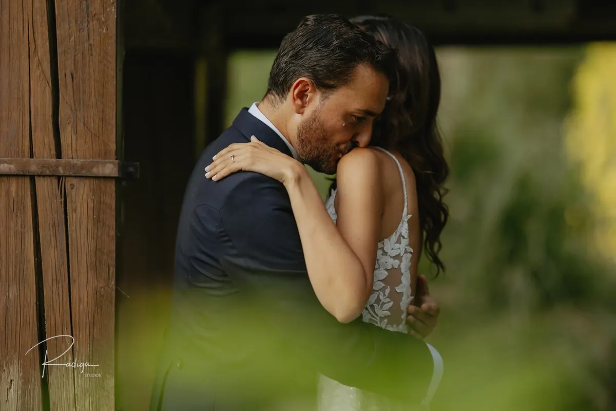 Los novios abrazados, enmarcados por una puerta de madera