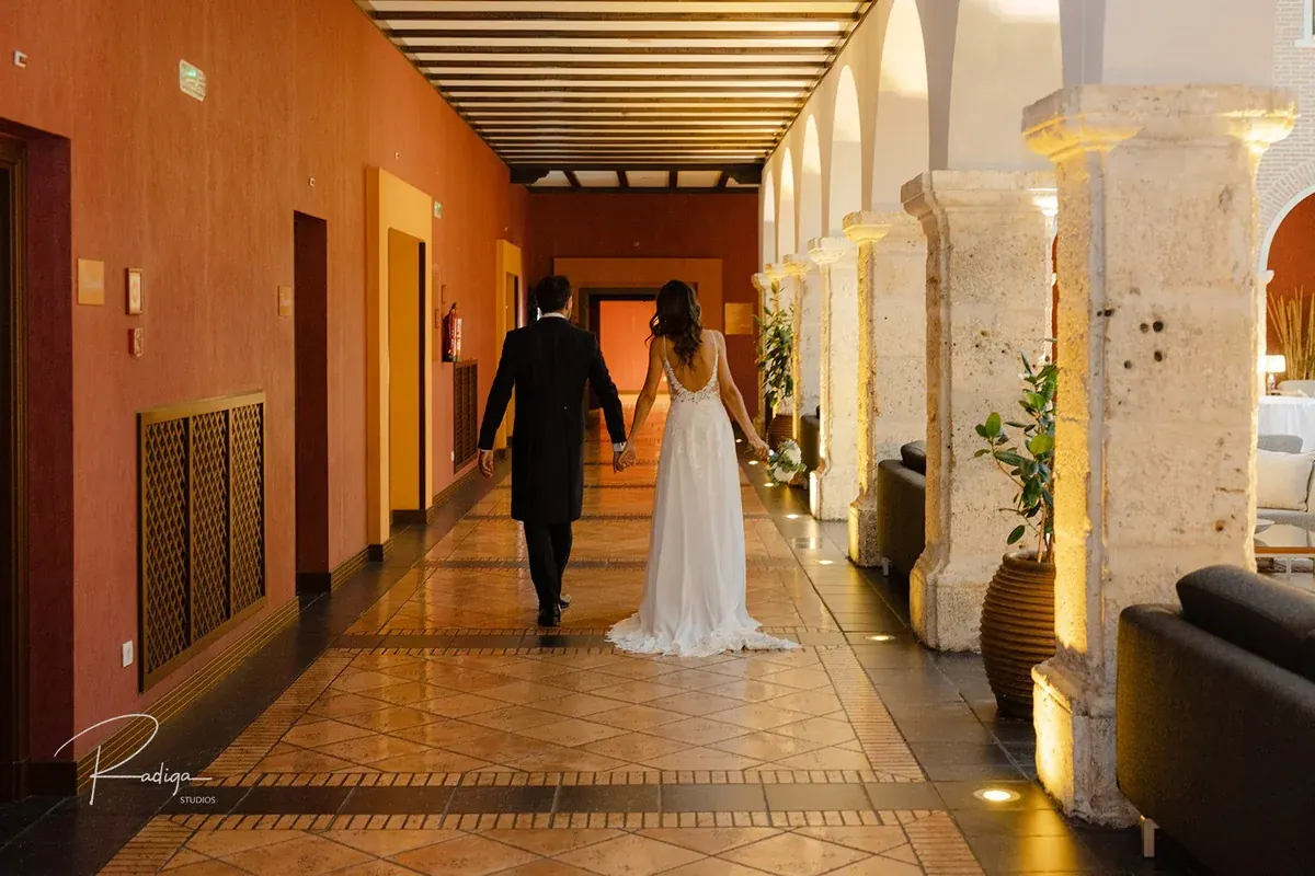 Los novios caminan por la galería de arcos del palacio
