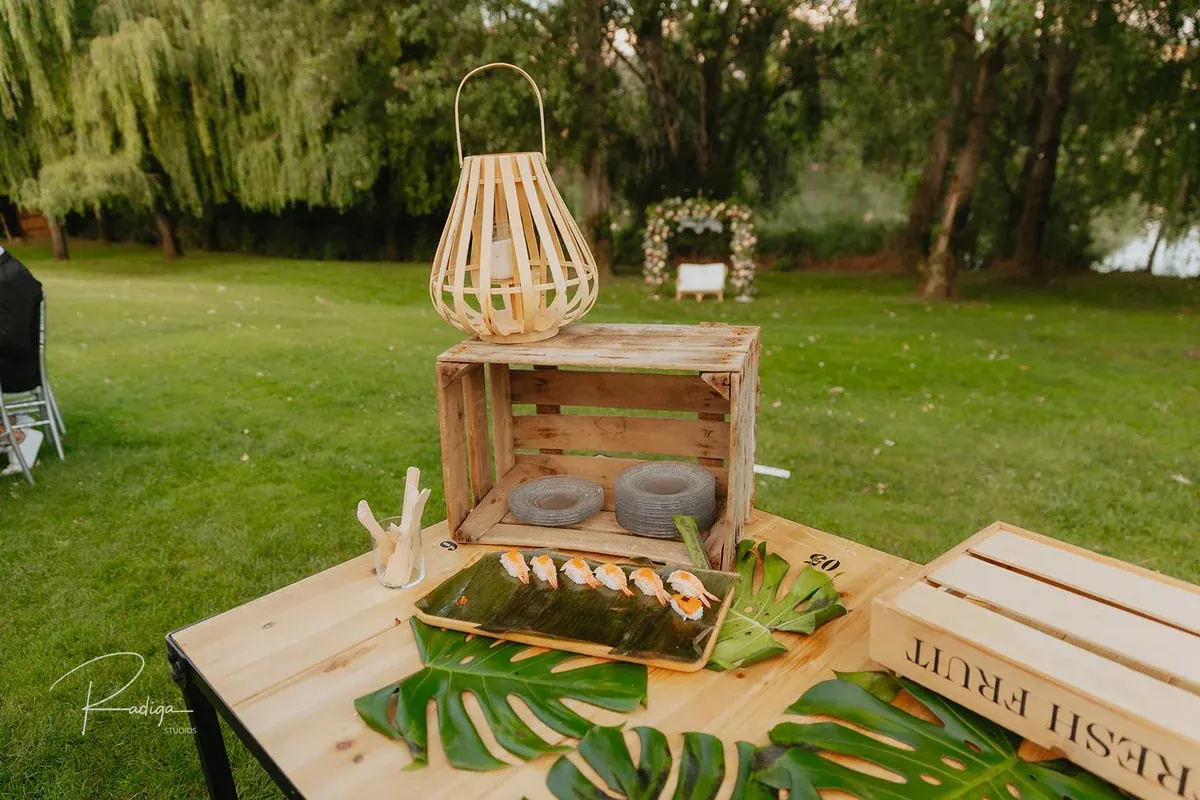 Mesa de madera con farol y hojas de palmera en el cóctel