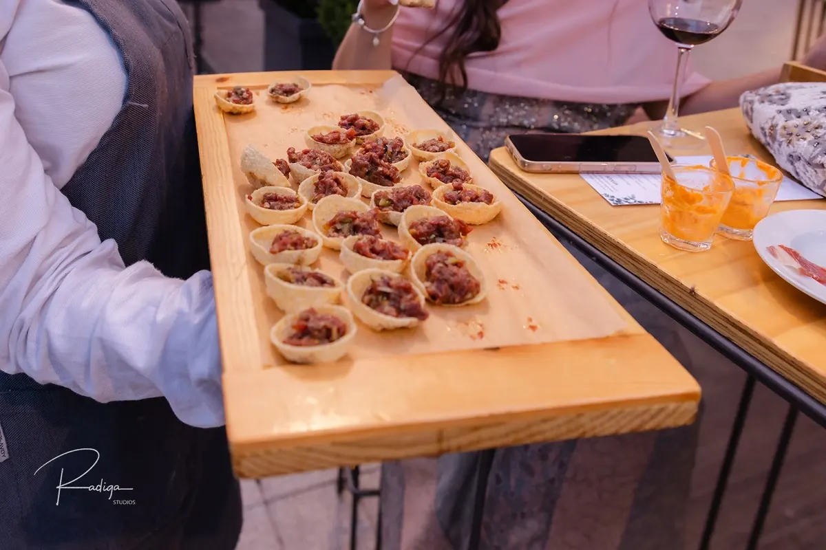 Una tabla de madera con aperitivos en el cóctel