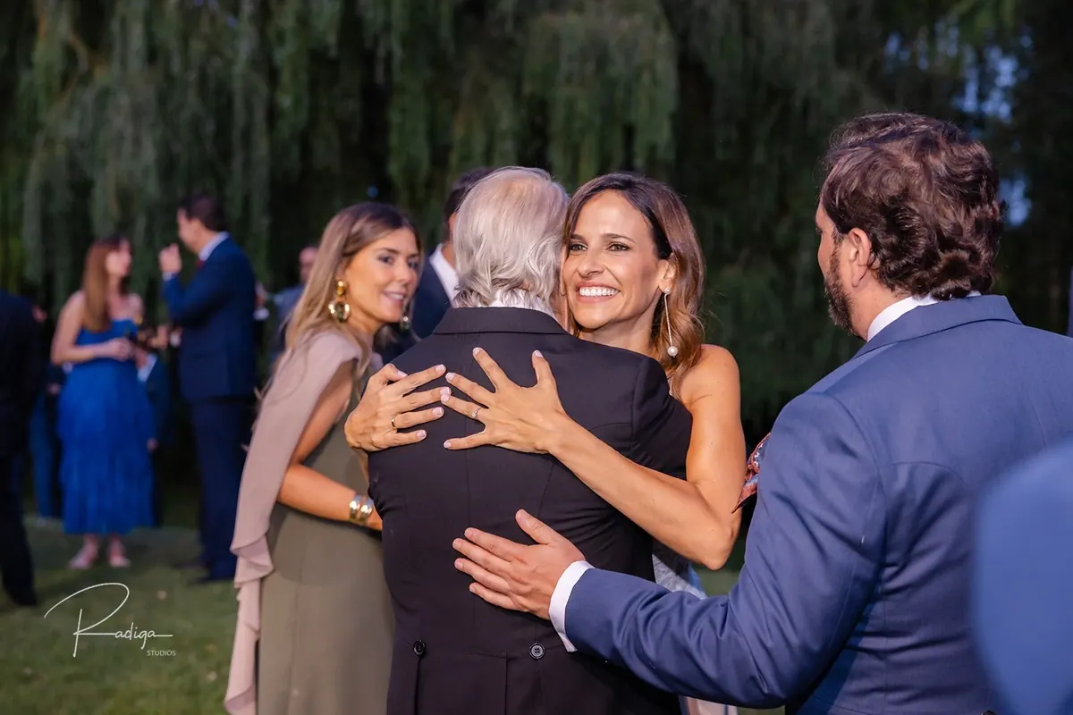 La novia abraza a un invitado en el cóctel
