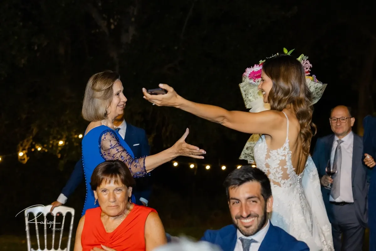 La novia celebra con las invitadas bajo las guirnaldas de luces