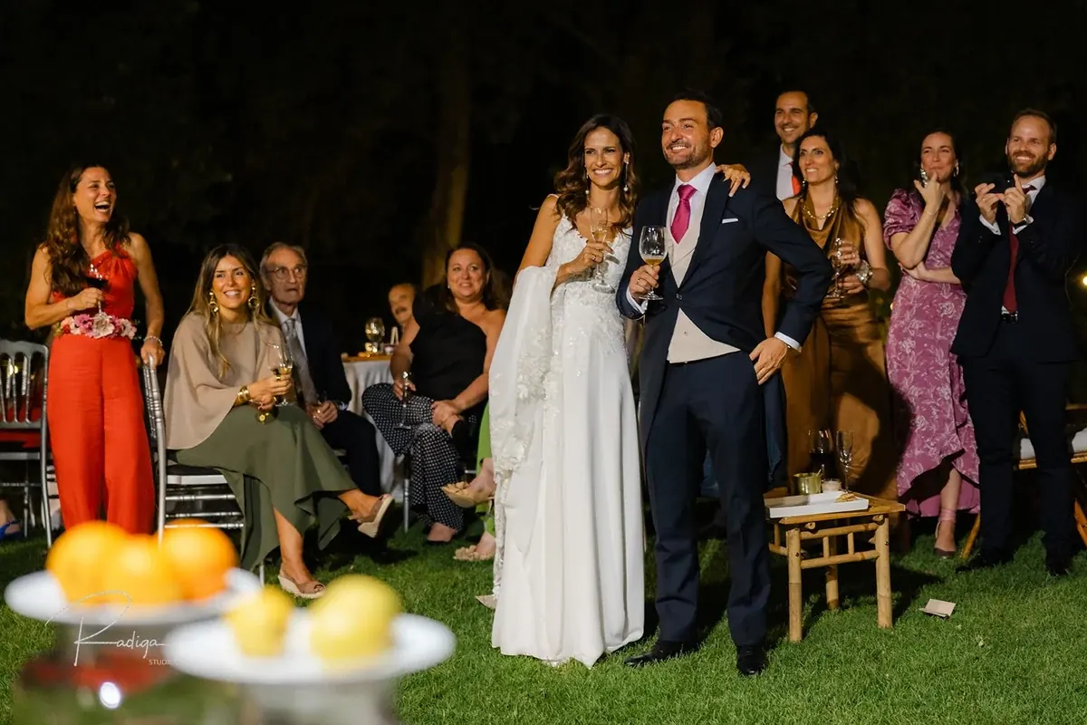 Los novios con sus amigos en el jardín por la noche