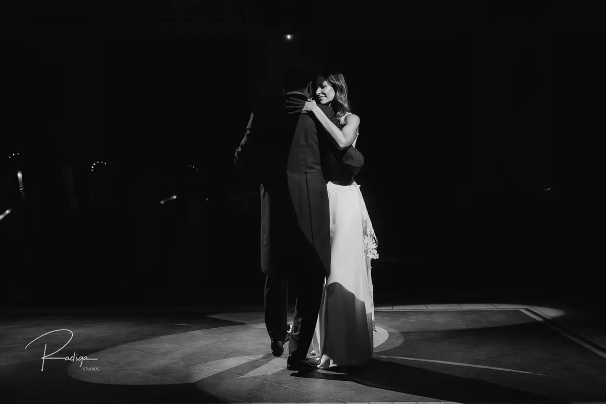 Los novios abrazados durante el primer baile, en blanco y negro