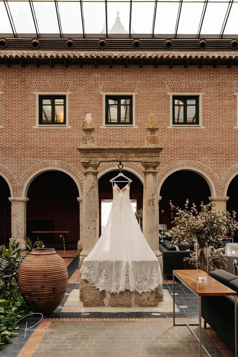 El vestido de novia colgado en una ventana del claustro de ladrillo