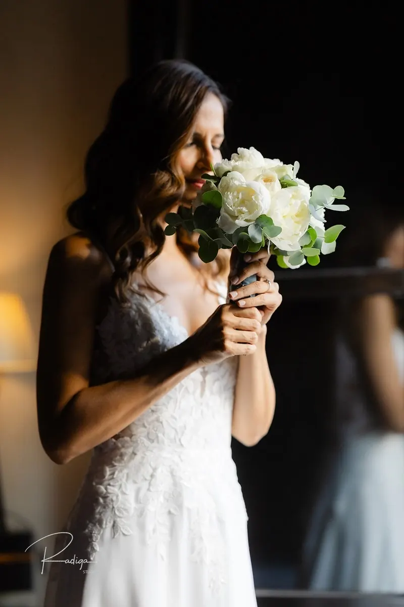 La novia acerca el ramo de rosas blancas a la cara