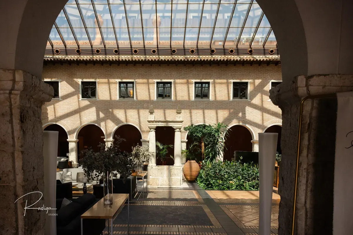El claustro acristalado del palacio visto a través de un arco
