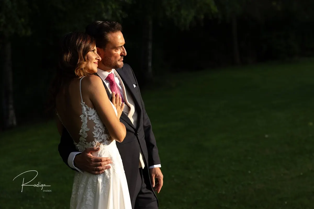 El novio abraza a la novia en el jardín