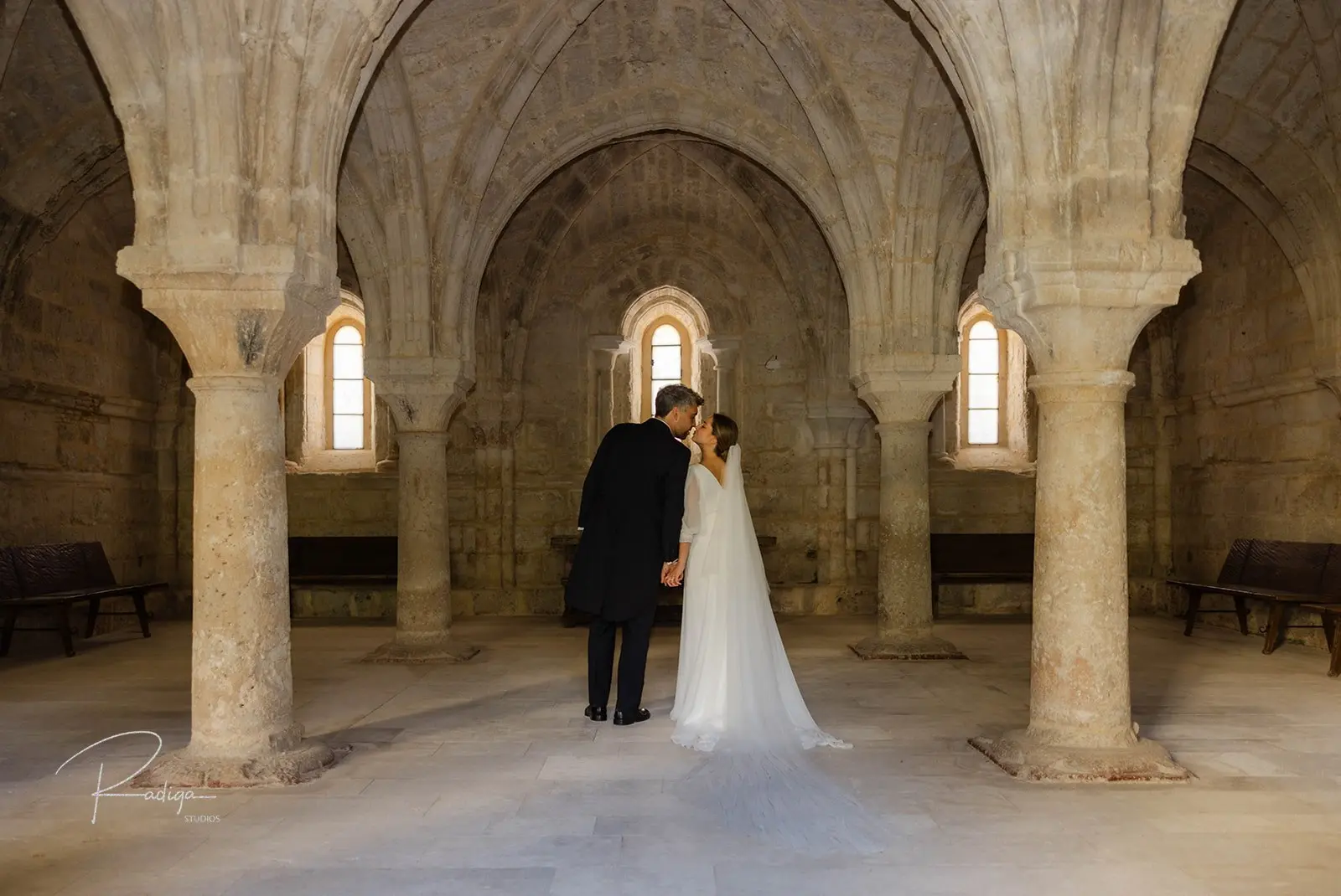Los novios en la sala capitular del monasterio, entre columnas y bóvedas