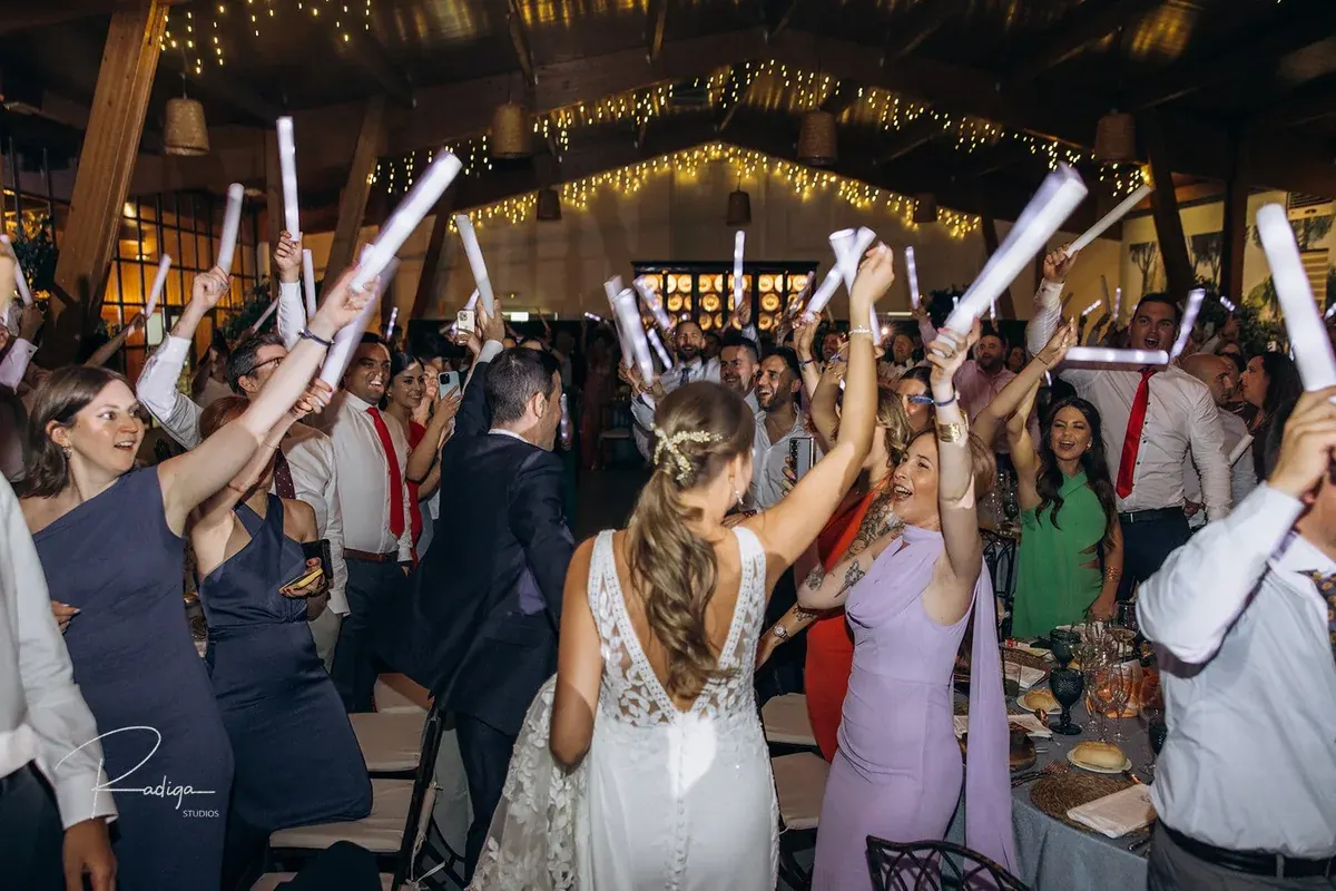 Los invitados reciben a los novios en el banquete con barras de luz