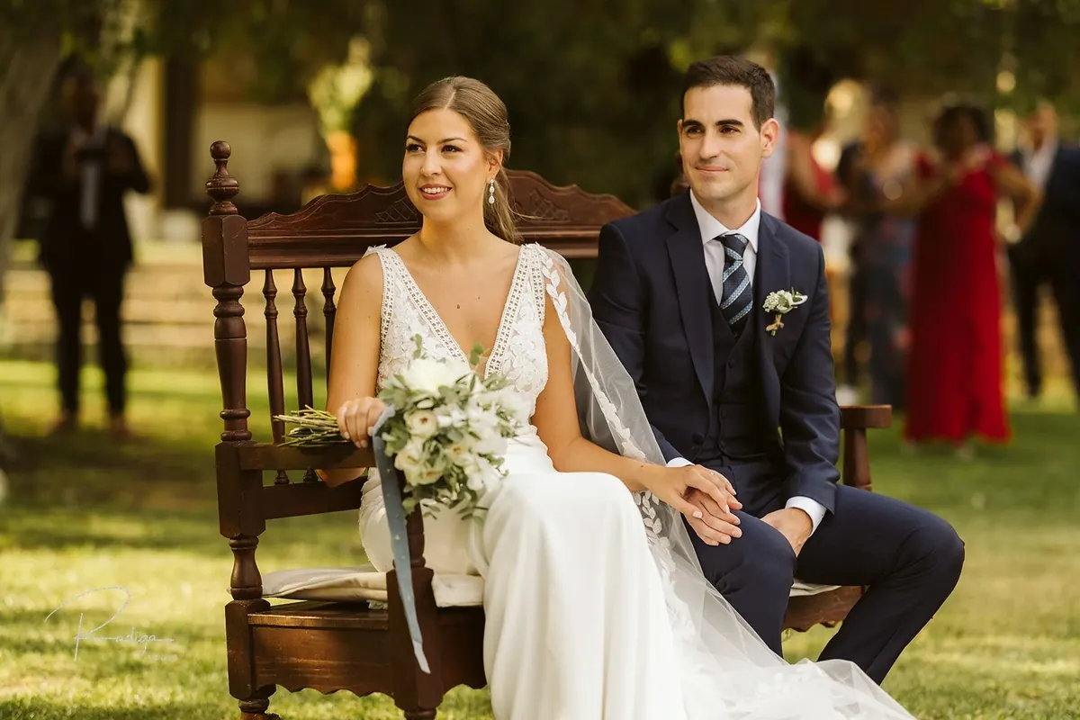 Los novios sonríen sentados durante la ceremonia