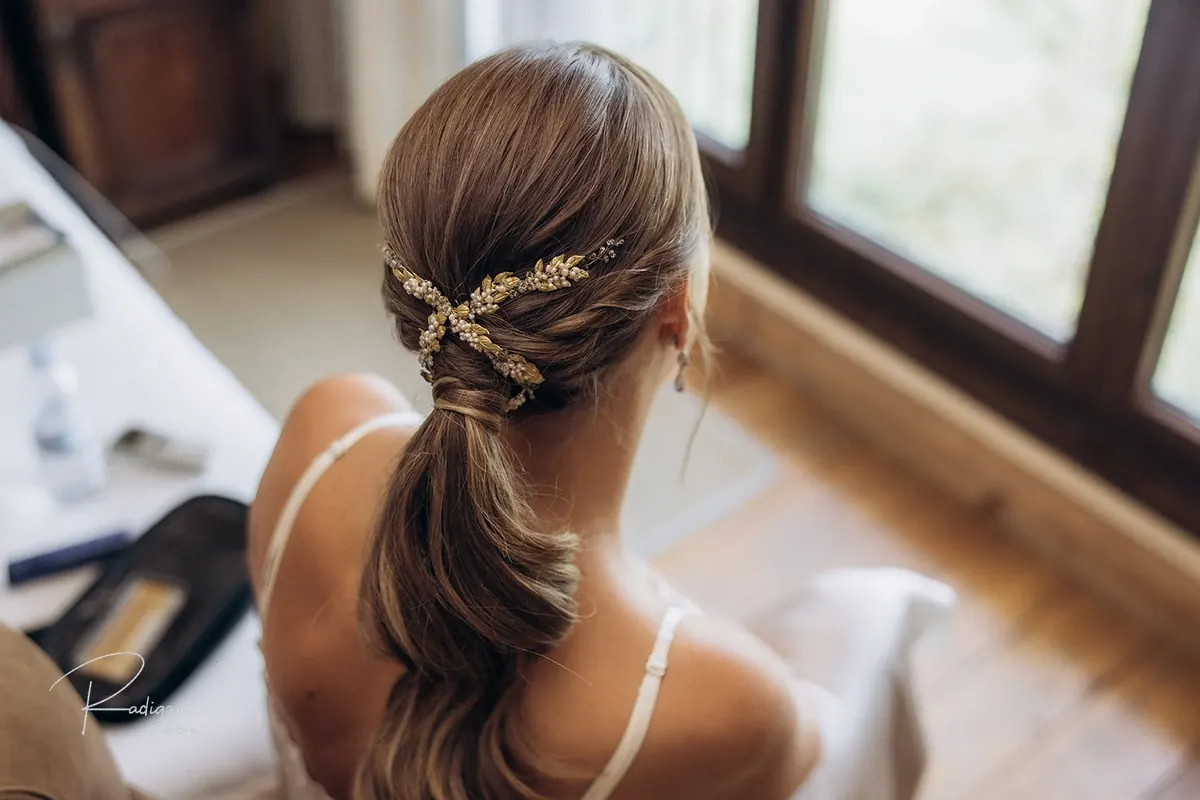 Detalle del recogido de la novia con un tocado dorado