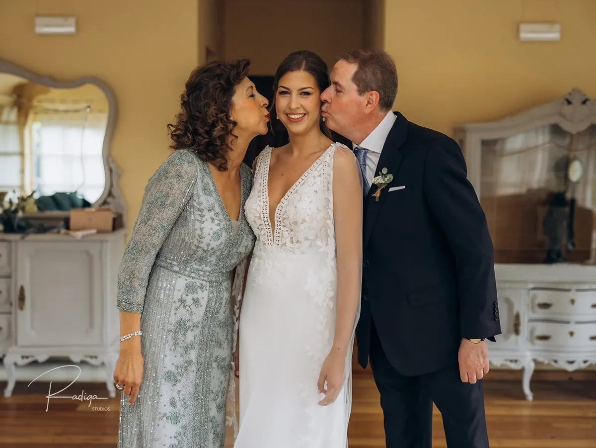 La novia con dos invitados en la habitación antes de salir