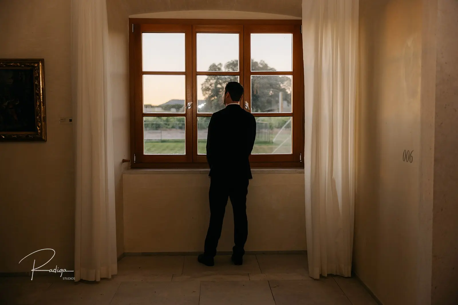 The groom getting ready by a window inside the abbey