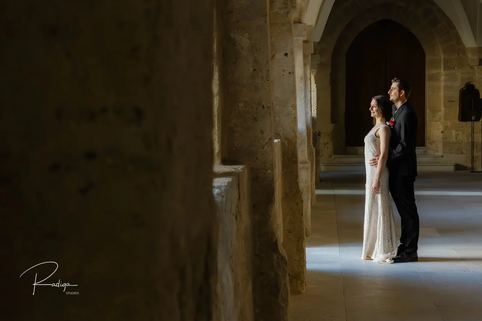 The couple in soft light inside the cloister of Abadía Retuerta