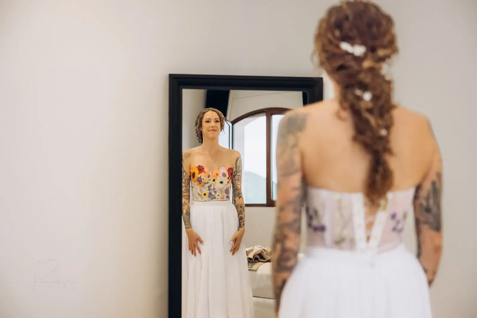The bride checking her braided hair in the mirror