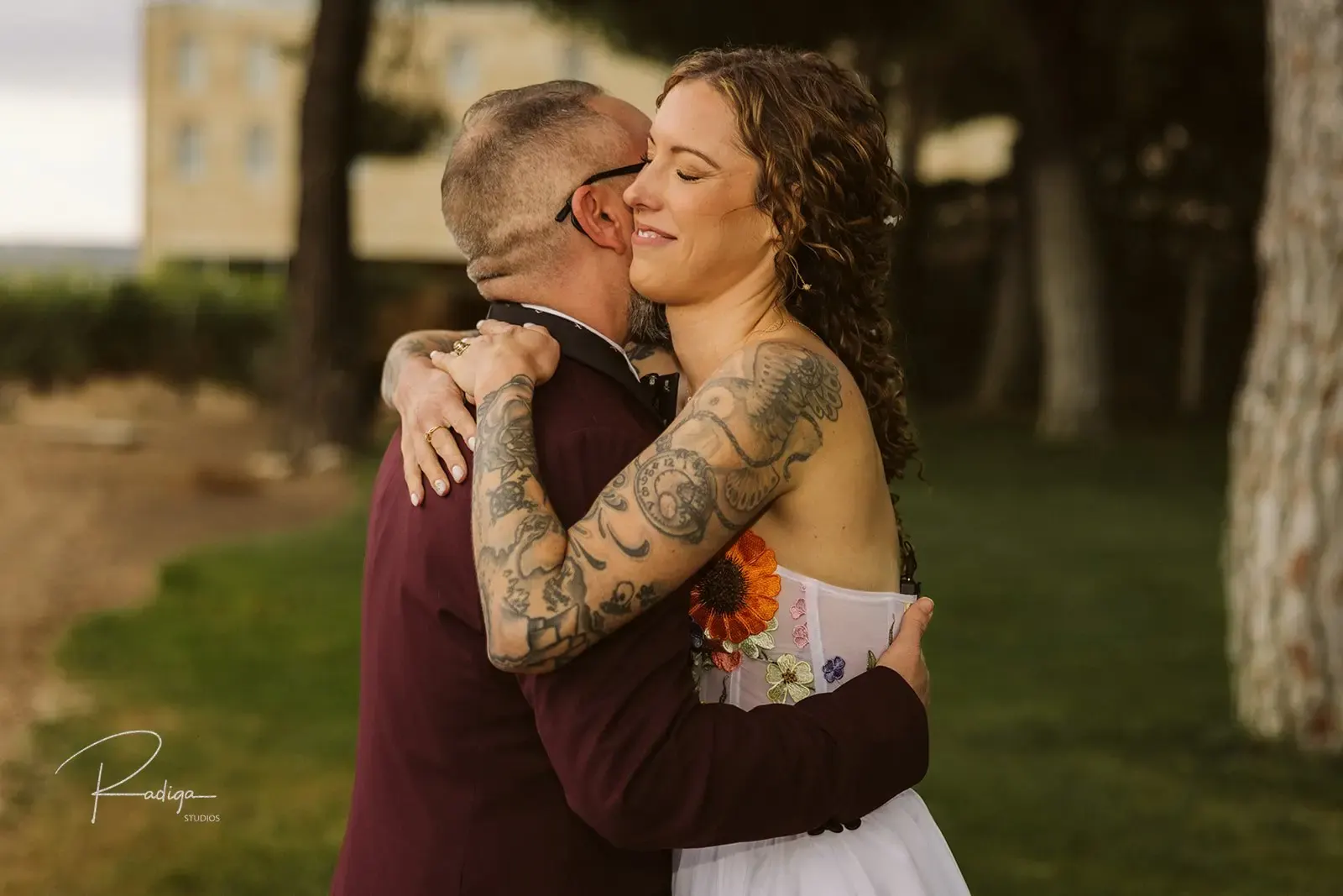 The couple hugging after the first look under the pine trees