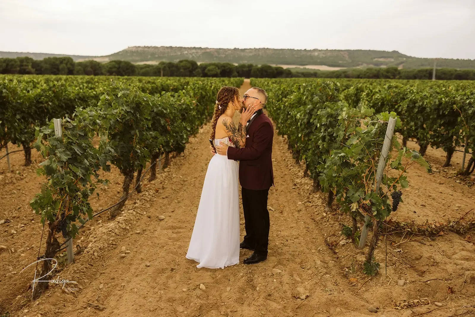 The couple standing together in the vineyards of Ribera del Duero