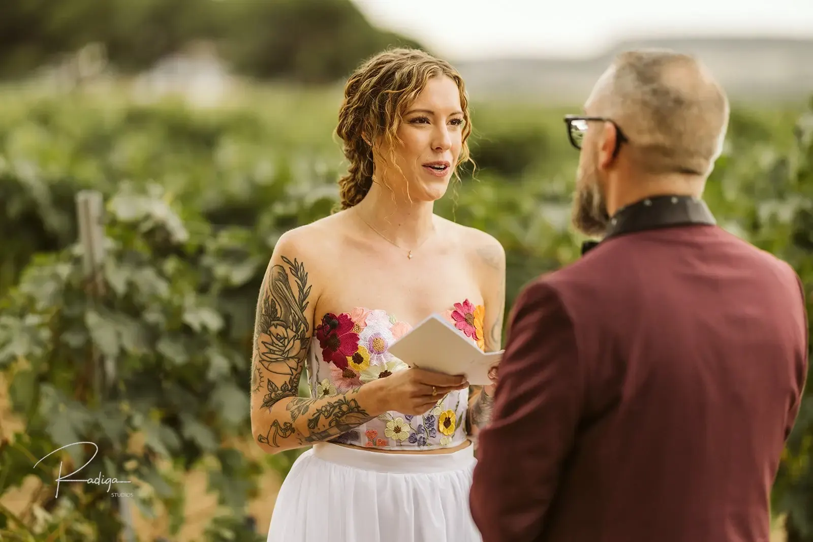 The bride reads her vows to the groom among the vines