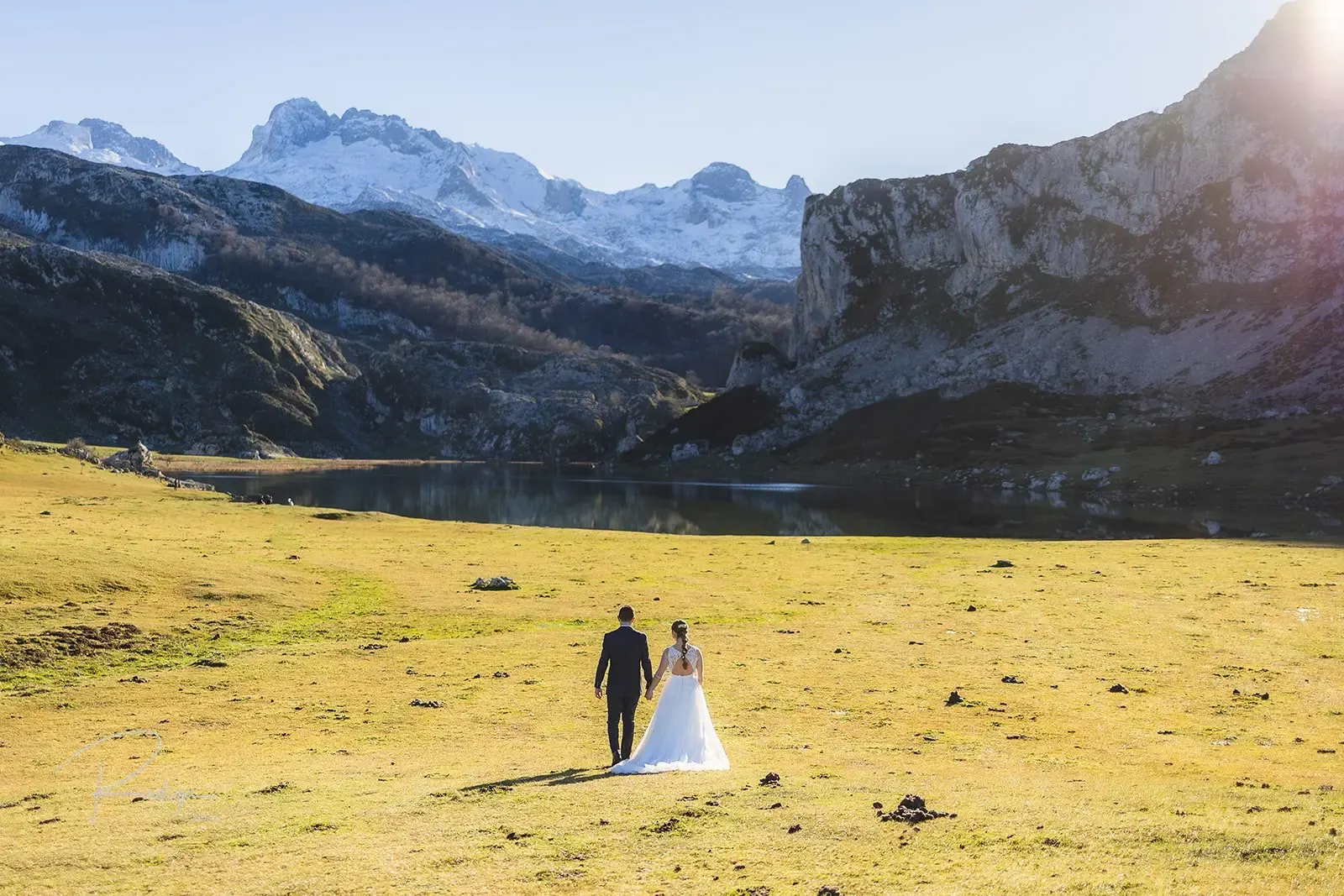 Los novios en la pradera junto a los Lagos de Covadonga con los Picos de Europa nevados al fondo