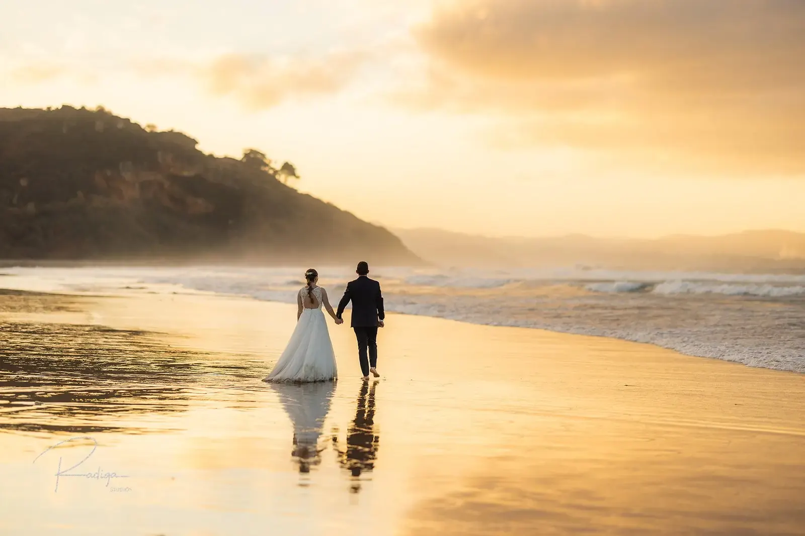 Los novios en la orilla de la playa de La Vega con la luz del atardecer
