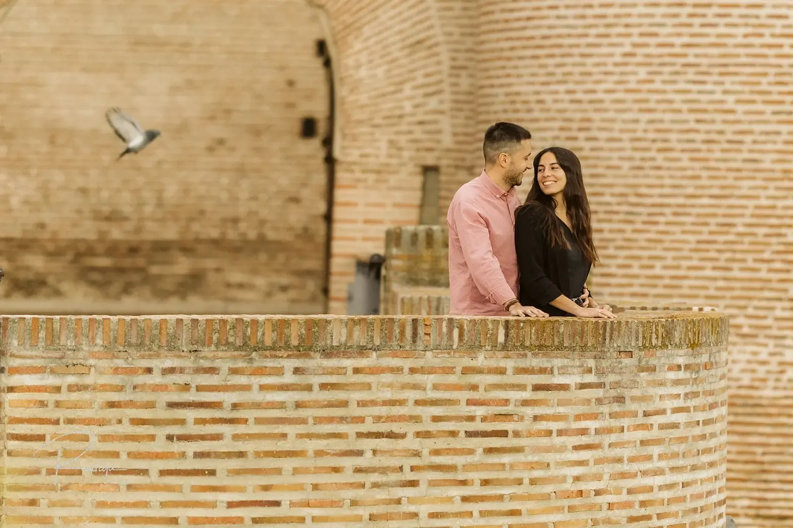 La pareja abrazada en lo alto de un torreón de ladrillo del Castillo de la Mota