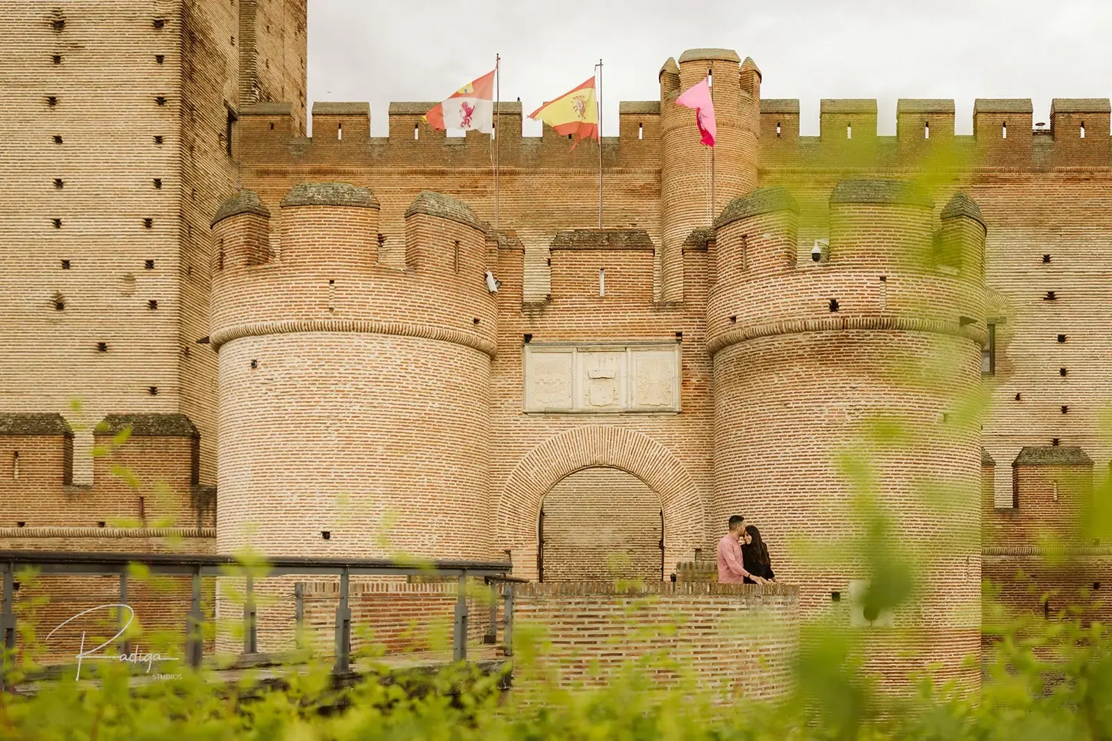 La pareja, pequeña, a los pies de las murallas del Castillo de la Mota