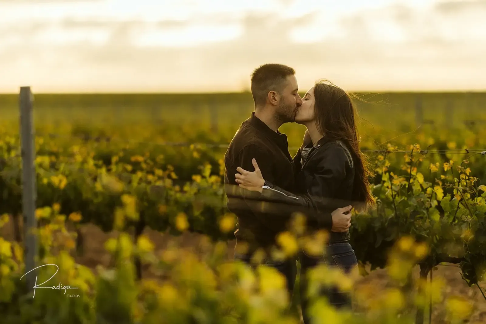 La pareja se besa entre las viñas al caer la tarde