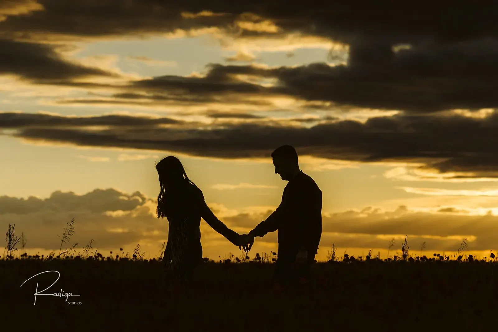 Silueta de la pareja de la mano con el cielo del atardecer